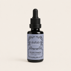 “DaFab vitamin D3 and K2 drops in minimalist amber glass bottle on soft cream background.”